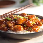 orange chicken rice bowl with sesame and scallions