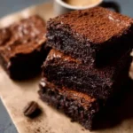 Delicious espresso brownies topped with chocolate drizzle on a rustic wooden table.