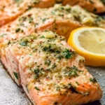Delicious garlic butter baked salmon dish served with herbs and lemon