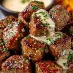 Delicious garlic butter steak bites with rich parmesan cream sauce on a plate.