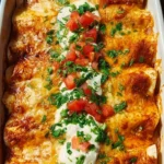Plate of ultimate quick and easy chicken enchiladas topped with cheese and sauce
