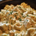 A bowl of creamy Chicken Alfredo Tortellini served with parsley garnish.