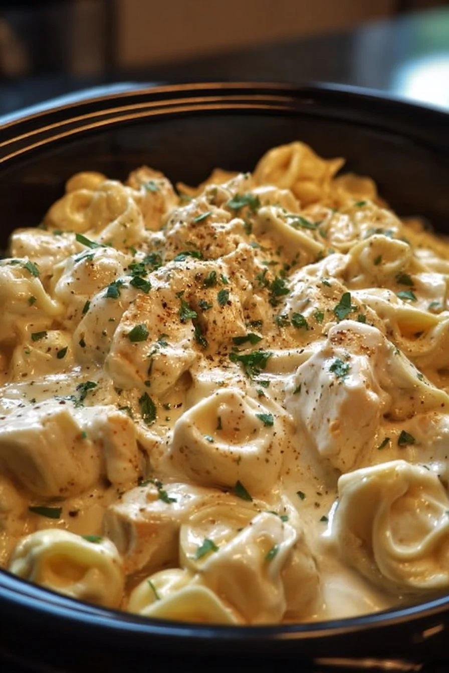 A bowl of creamy Chicken Alfredo Tortellini served with parsley garnish.
