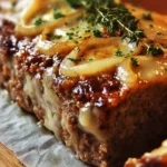 Delicious French Onion Meatloaf topped with melted cheese and caramelized onions