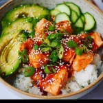 Delicious Honey Sriracha Salmon bowl garnished with vegetables and herbs.