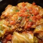 Slow cooker unstuffed cabbage rolls in a rustic bowl served with fresh herbs.